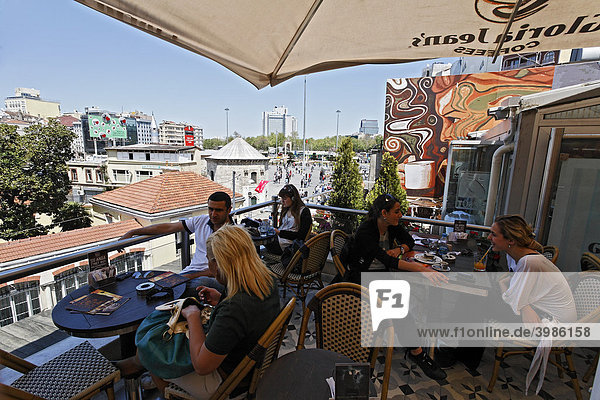 Young people on the roof terrace of a cafe  overlooking the Taksim Square  Istiklal Caddesi  Beyoglu  Istanbul  Turkey