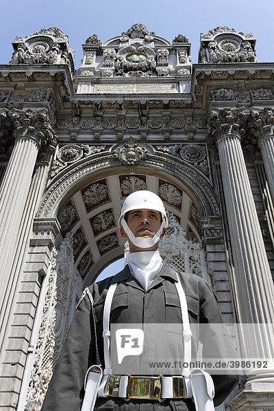 Junger Wachsoldat mit weißem Helm steht vor prunkvollem Eingangstor  Dolmabahce-Palast  Sultanspalast aus dem 19. Jh.  Besiktas  Istanbul  Türkei