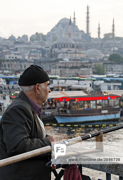 Turkish angler with cap on the Galata bridge  portrait  Eminoenue  Istanbul  Turkey