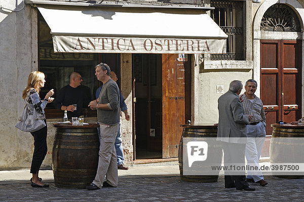 Curbside conversation at a local cafe  Bassano del Grappa  Veneto  Italy  Europe