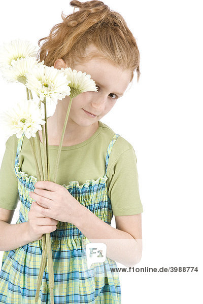 Rothaariges Mädchen versteckt sich hinter weißen Gerbera Blumen