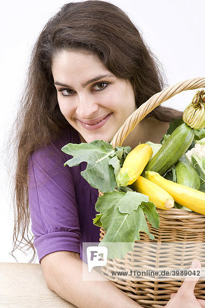 Strahlendes Mädchen mit Gemüsekorb