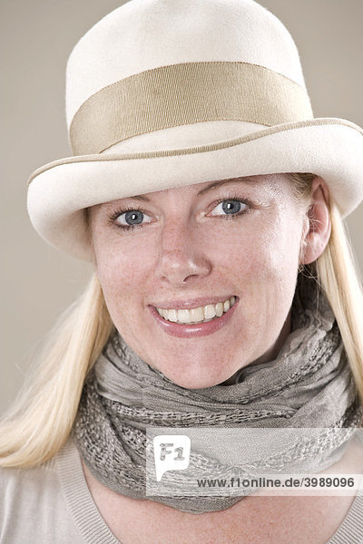 Junge blonde Frau mit Hut lächelt