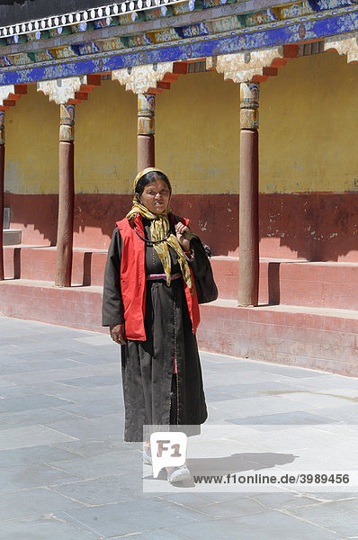 Kloster Thikse  Frau in traditionellem Mantel  Goncha  und modernem Anorak auf dem Klosterhof  Ladakh  Jammu und Kashmir  Nordindien  Himalaja  Asien
