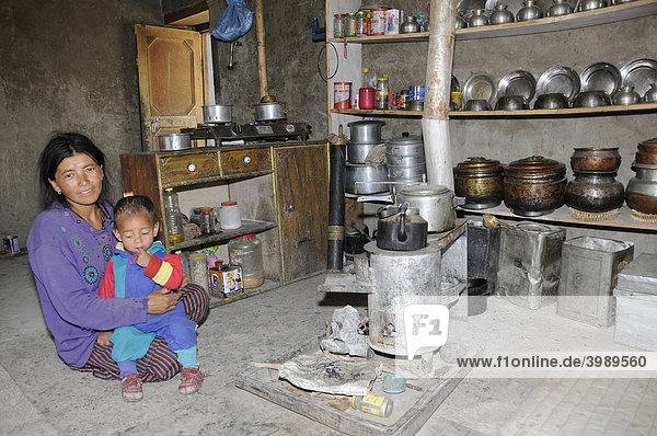 Bäuerin in ihrer Küche mit Metallarbeiten  Kupfer und Messing  auf dem Tellerbord von dem ehemaligen Kupferschmied  Chiling  Zanskartal  Ladakh  Indien  Himalaja  Asien