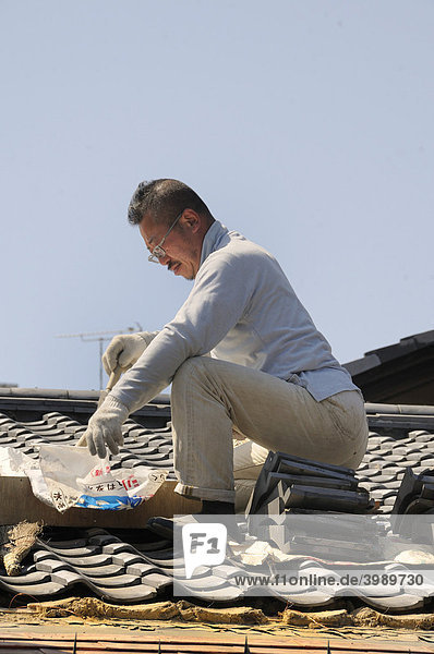 Roofers repaired a traditional roof  tiles on a clay bed  Kyoto  Japan  Asia