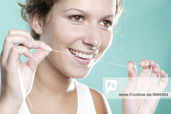 Junge Frau mit Zahnseide