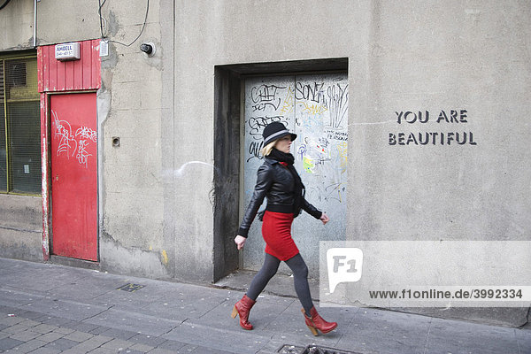 Modisch gekleidete junge Frau in der Palace Straße mit Schrift You are beautiful Du bist schön  Dublin  Irland