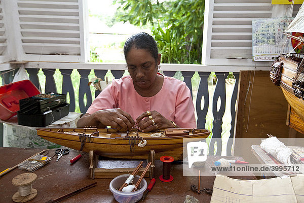 Eine Frau fertigt ein Miniatur Segelschiff  Craft Village  Handarbeiten der Seychellen  Insel Mahe  Seychellen  Indischer Ozean  Afrika