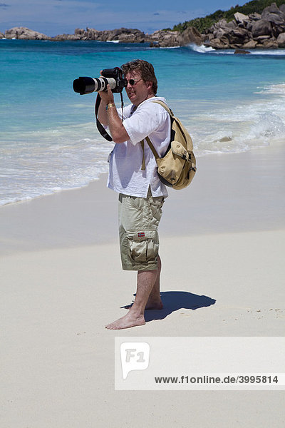 Imagebroker-Fotograf bei der Arbeit am Strand von Grand Anse mit den typischen Granitfelsen von La Digue  Indischer Ozean  Insel La Digue  Seychellen  Indischer Ozean  Afrika