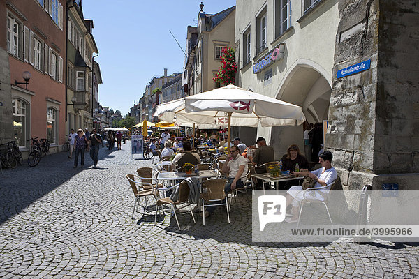 Touristen sitzen in einem Straßencafe in der Maximilianstraße in Lindau  Lindau am Bodensee  Bayern  Deutschland  Europa