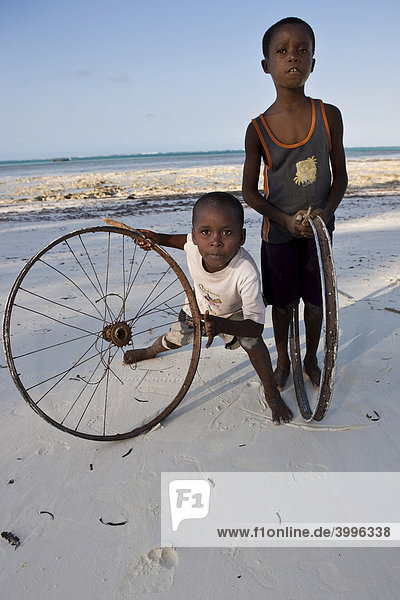 Children playing with old bicycle wheels on the beach of Pingwe  Zanzibar  Tanzania  Africa