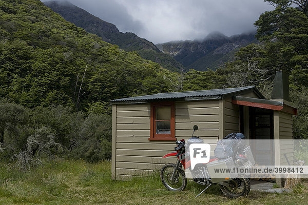 Schwer bepacktes Enduro Motorrad vor einer Wanderhütte in der Nähe des Mount Cashel  Südinsel  Neuseeland