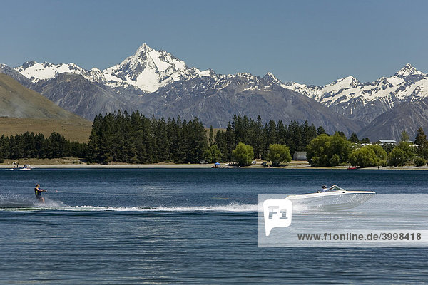 Wasserskifahrer hinter einem Motorboot auf dem Lake Camp mit Blick auf die Berge der Cloudy Peak Range  Südinsel  Neuseeland