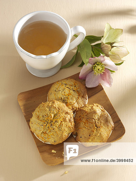 Möhrenlebkuchen auf Holzbrett mit weißer Teetasse und Christrose (Helleborus niger) - Rezeptdatei vorhanden