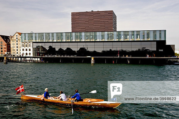 Drei Frauen rudern ein Boot vor dem Royal Danish Playhouse Theater  Kopenhagen  Dänemark