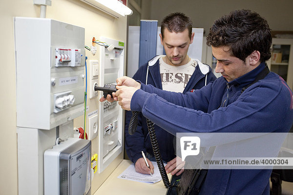 Master electrician students using a voltmeter on a VDE measuring station  control panel  fuse box  master electrician from the Master Craftman School of the Chamber of Small Industries and Skilled Trades  Dusseldorf  North Rhine-Westphalia  Germany  Europe