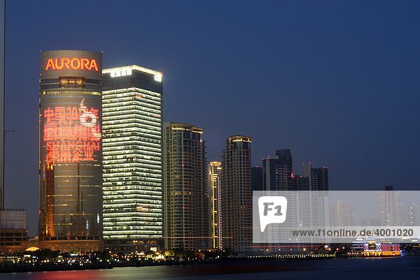 Erleuchtete Skyline mit chinesischer Leuchtreklame des Finanzdistrikts Pudong in Shanghai mit Fluss Huangpu  Shanghai  China