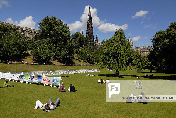 People relaxing in a park  in front of the Scott Monument in Edinburgh  Scotland  UK  Europe