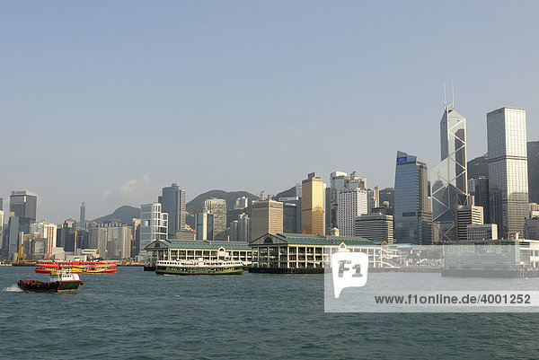 Fährschiff der Star Ferry und Schlepper vor der Skyline und Pier von Hongkong Central  Hongkong  China  Asien