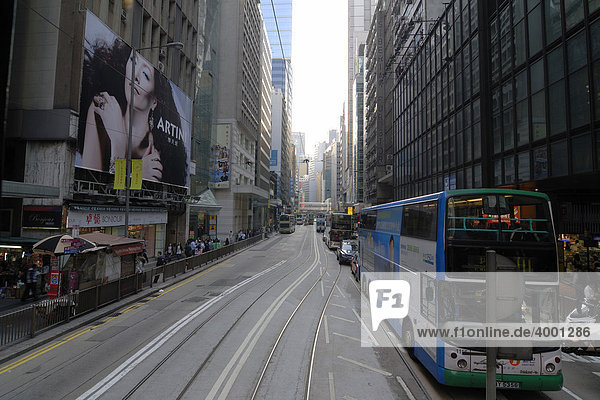 Dichter Verkehr mit Doppelstockbussen  Doppeldeckern  und Doppelstock-Straßenbahnen  Tram  in den engen Straßen von Hongkong zwischen Hochhäuser  Wolkenkratzer in Central  Hongkong  China  Asien