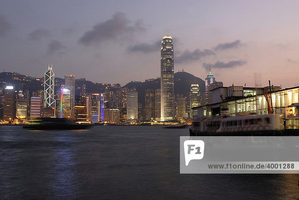 Star Ferry am beleuchteten Pier der Star Ferry Kowloon mit Blick auf die abendlich erleuchtete Skyline von Hongkong Central  Finanzdistrikt  Hongkong  China  Asien