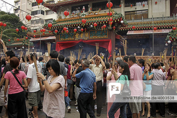 Chinese New Year ceremony with incense sticks in front of the buddhist Kwam Im Tong Hood Che temple in Singapore  Asia