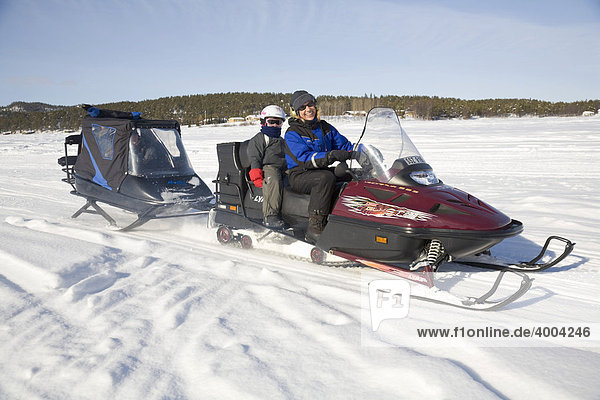 Woman  in her forties  and a girl  6  on a snowmobile tour in Kiruna  Lappland  North Sweden  Sweden