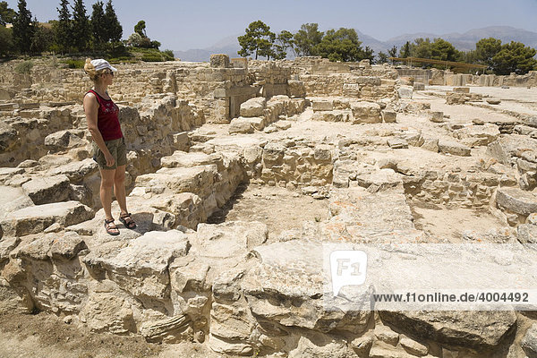 Eine Touristin steht inmitten der Ausgrabungsstätte der minoischen Paläste von Festos  Insel Kreta  Griechenland