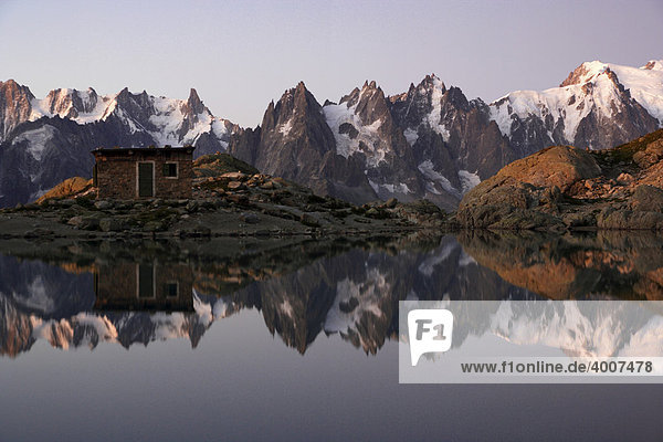 The Aiguilles de Chamonix mountains reflected in Lac Blanc lake  far right Mont Blanc before sunrise  Haute-Savoie  France  Europe