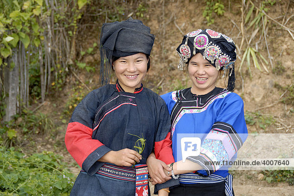 Portrait  zwei junge Frauen der Hor-Lolo Ethnie lachen in ihrer Tracht mit Kopfschmuck  Phongsali  Laos  Südostasien  Asien
