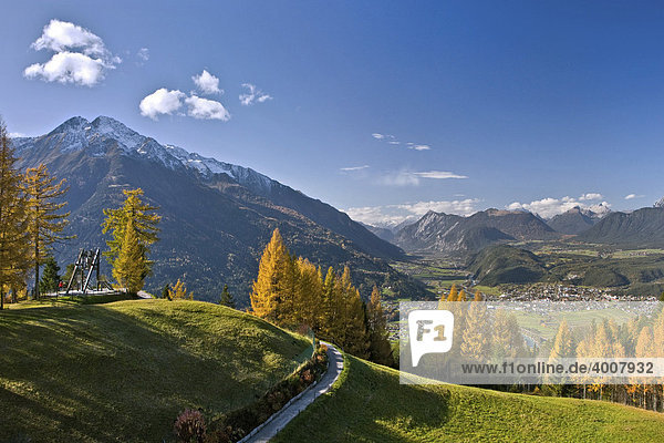 Friedensglocke in Mösern  Lärchen im Herbst  Hocheder in den Stubaier Alpen  Blick ins Inntal  Telfs  Tirol  Österreich  Europa