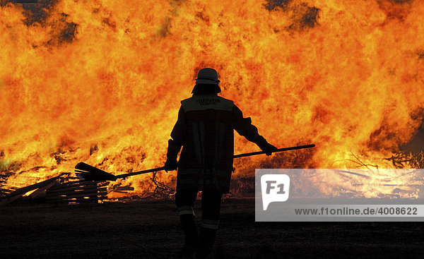 Feuerwehrmann steht vor Flammenwand
