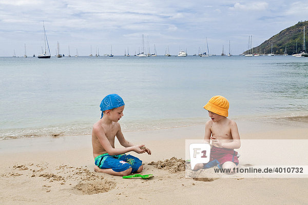 Zwei Jungen 5 und 6 Jahre spielen am Sandstrand Nai Harn Beach Insel Phuket Südthailand Thailand Südostasien Asien