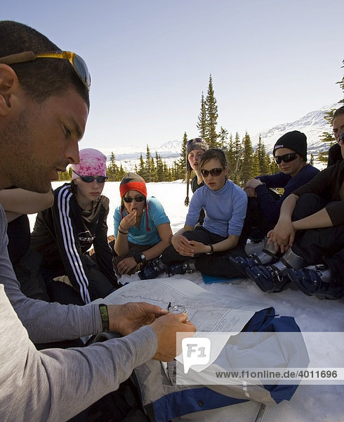 Teacher explains navigation with map and compass to a group of children  Yukon outdoor school program  White Pass  Chilkoot Pass  Chilkoot Trail  British Columbia  B.C.  Canada