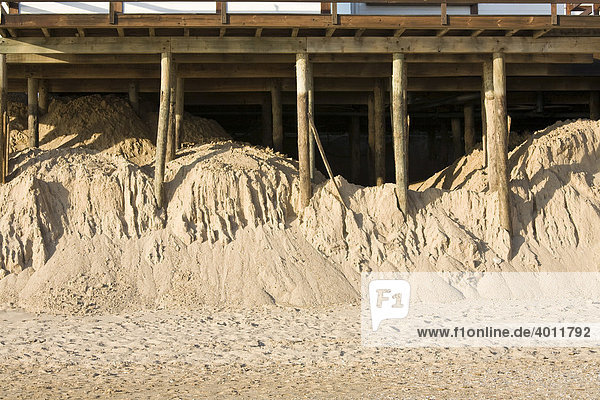 Bodenerosion  vom Meer fast weggespülte Strandbar auf Holzpfählen im Sand an der Algarve  Praia Alvor  Portugal  Europa