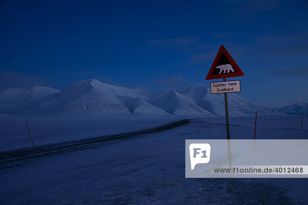 Straßenschild mit Eisbär und Berge in der Polarnacht auf Spitzbergen