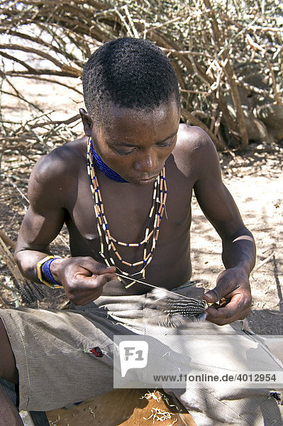 Ein Angehöriger der Hazabe-Stammesgruppe fertigt einen Jagdpfeil  Lake Eyasi  Tansania  Afrika
