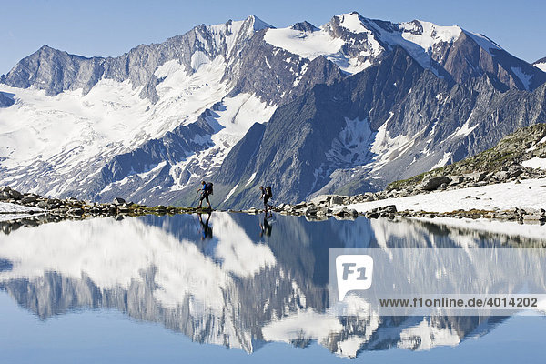 Hikers on the shore of the Friesenbergsee lake  Zillertal Alps  Northern Tyrol  Austria  Europe