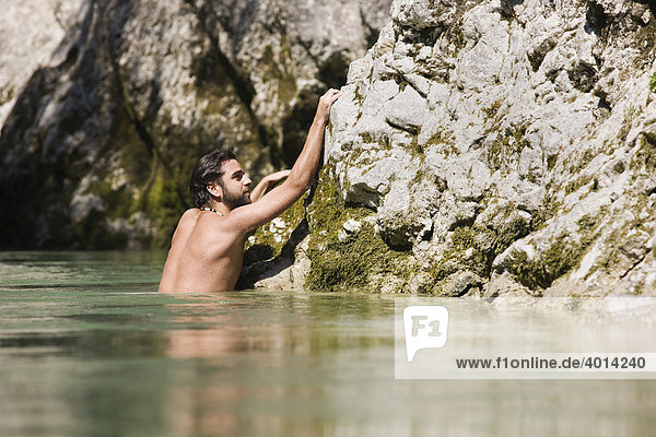 Schwimmer klettert auf Felsen in der Brandenberger Ache  Nordtirol  Österreich  Europa