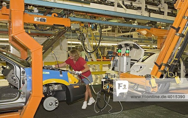 A member of the United Auto Workers union assembles the Chrysler Sebring sedan at Chrysler's Sterling Heights Assembly Plant  here a worker hooks up hoses from a robot that will fill a new car with antifreeze and other fluids  Sterling Heights  Michigan  USA