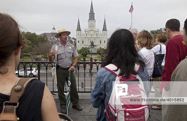 Ein Aufseher der Jean Lafitte National Historic Park and Preserve geschützen Parkanlage erzählt Touristen über die Geschichte New Orleans vor dem Jackson Square Platz und der St. Louis Kathedrale  New Orleans  Louisiana  USA