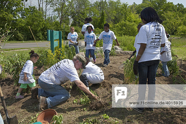 Volunteers work on landscaping improvements at an entrance to Rouge Park  Detroit  Michigan  USA
