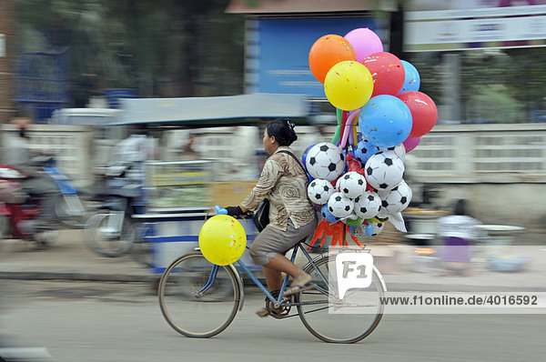 Luftballonverkäuferin auf einem Fahrrad  Kambodscha  Asien