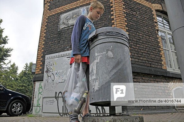 Ein neunjähriger Junge verdient sein Taschengeld durch Sammeln von Pfandflaschen  Deutschland  Europa