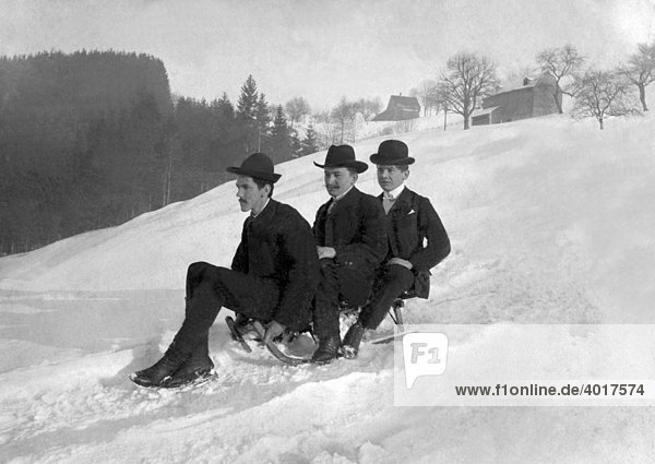 Three gentlemen riding a sled  historical image  ca. 1912