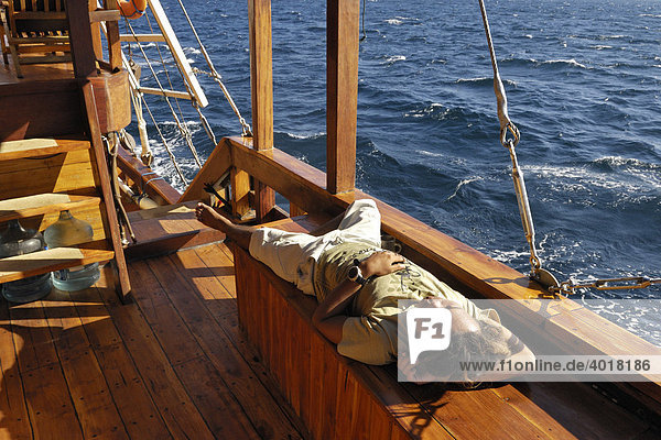Divemaster relaxing on the deck of the MS-Felicia  Komodo National Park  World Heritage Site  Komodo  Indonesia  Asia