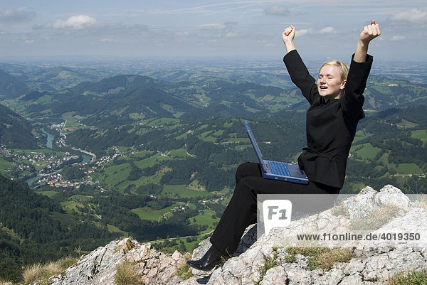 Geschäftsfrau am Gipfel mit einem Laptop