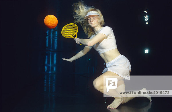 Frau spielt Tennis unter Wasser