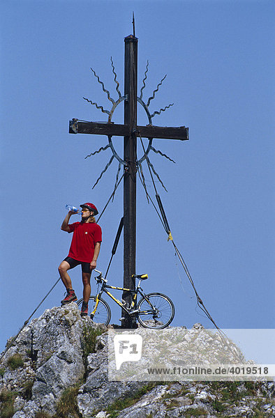 Radfahrer mit Mountainbike beim Gipfelkreuz  Reichraming  Oberösterreich  Österreich  Europa